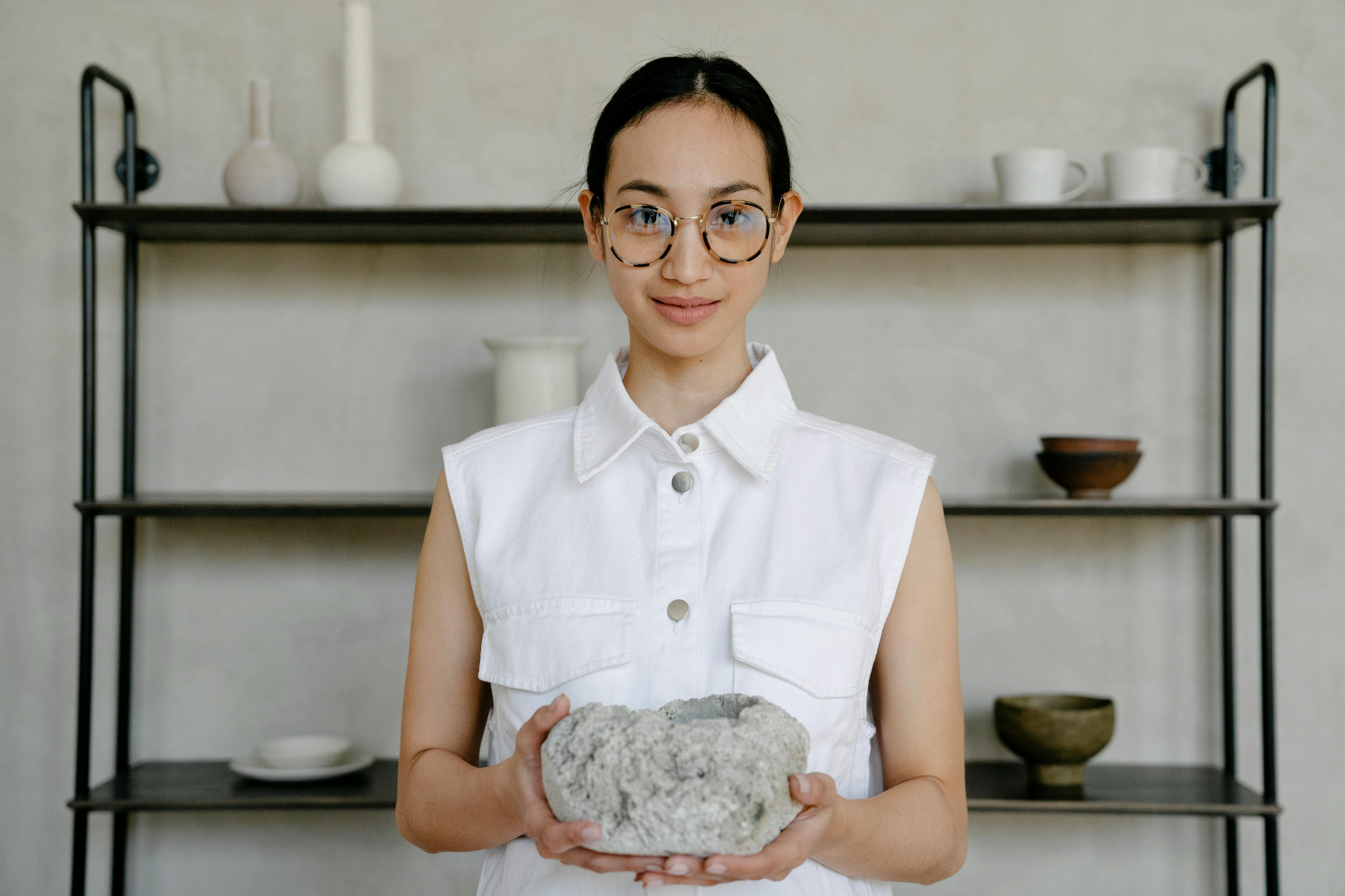 A Woman in White Sleeveless Shirt Holding a Rock