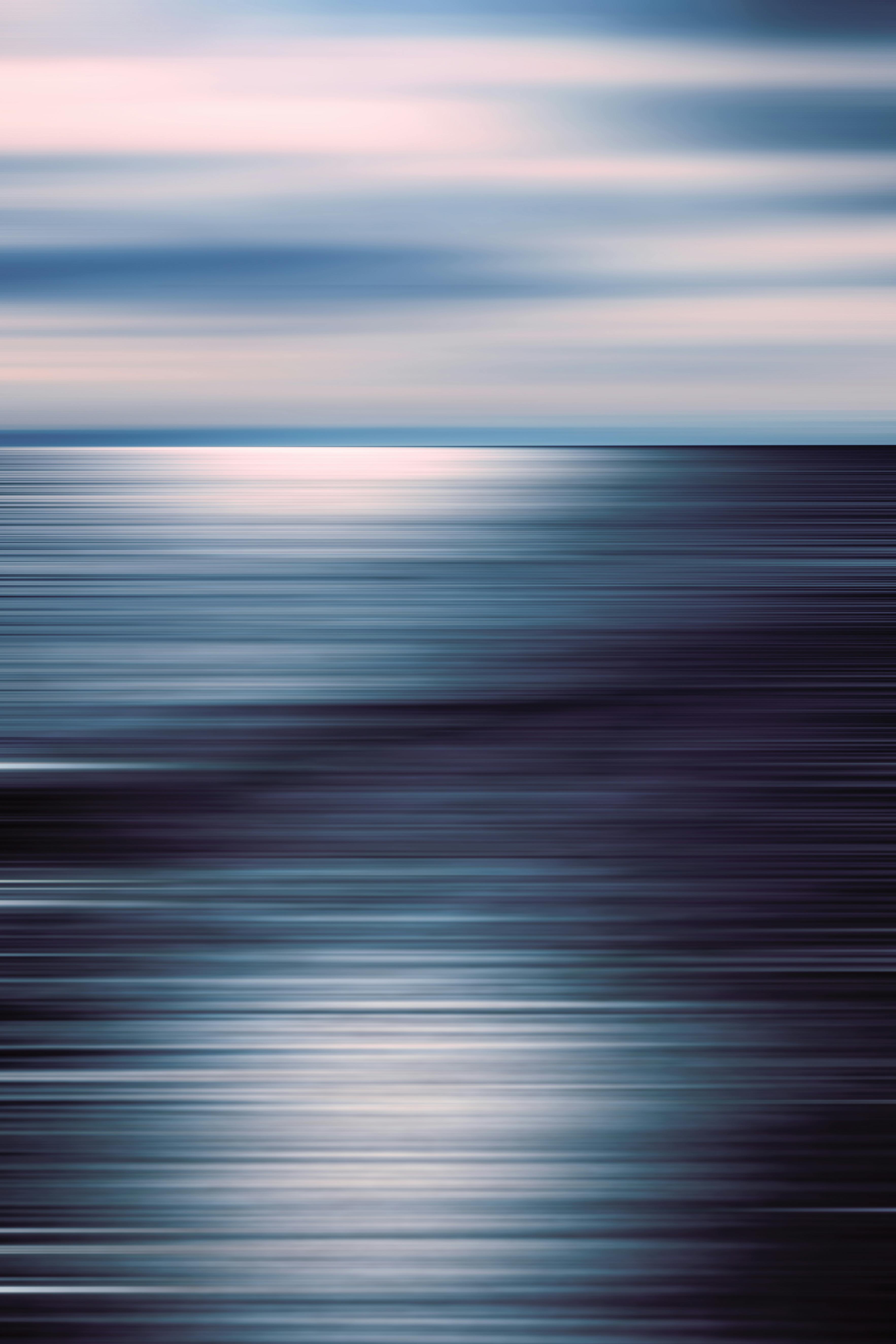 Artistic abstract view of a calm ocean horizon with reflective light and blurred effect.