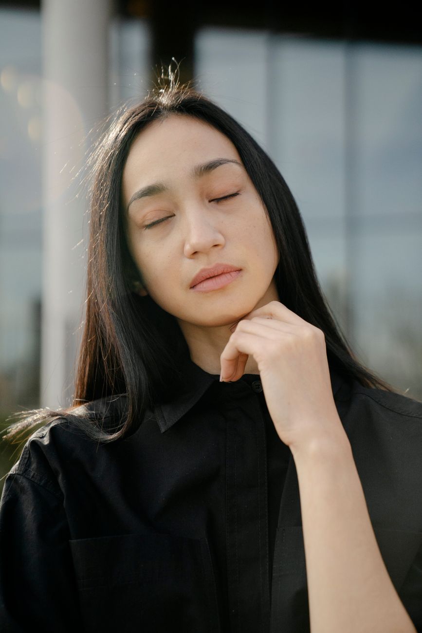 Close-up portrait of a woman with eyes closed, expressing calm and simplicity.