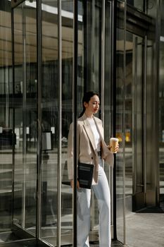 Woman in White Coat Holding White Paper Bag