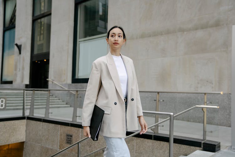 Asian Businesswoman With Folder In City