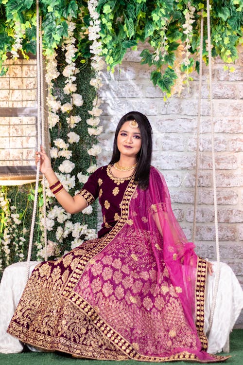 Woman in a Traditional Dress Sitting on a Swing