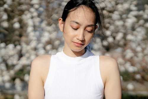 Tender ethnic woman in windy weather on sunny day