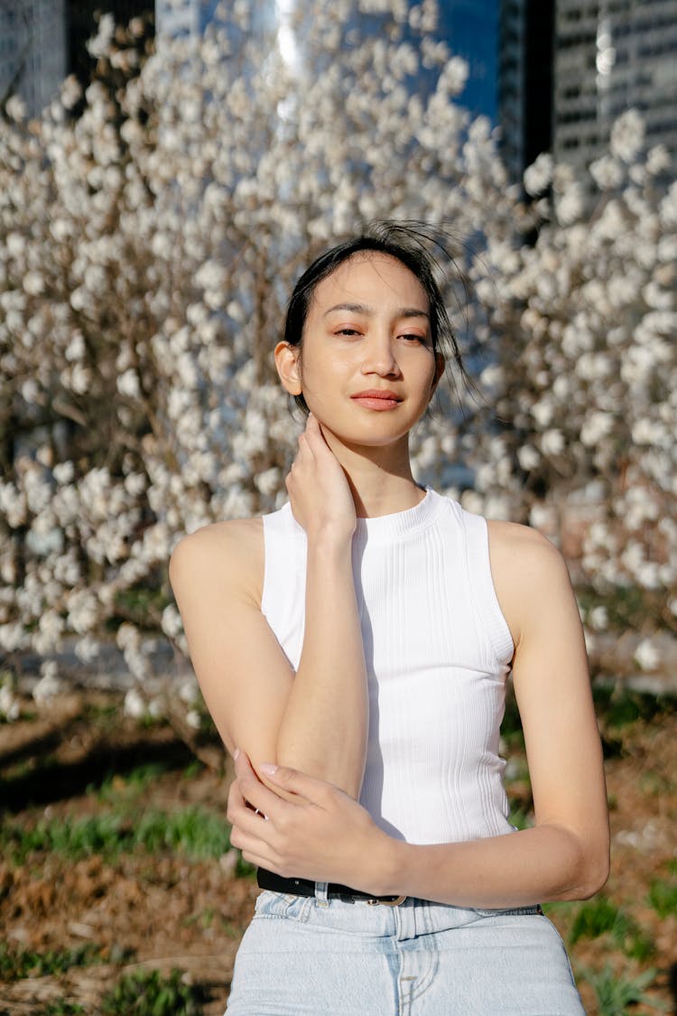 Tender Asian Woman Touching Neck In City Park