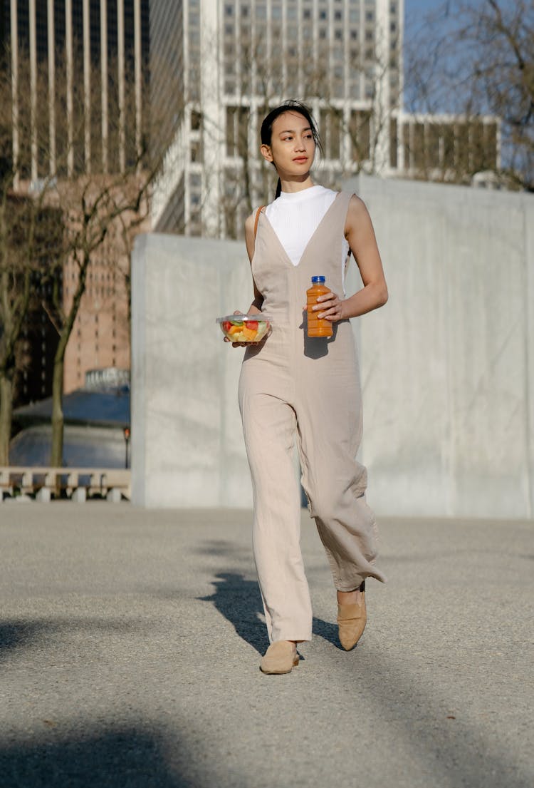 Stylish Asian Woman With Beverage And Fruit Salad On Street