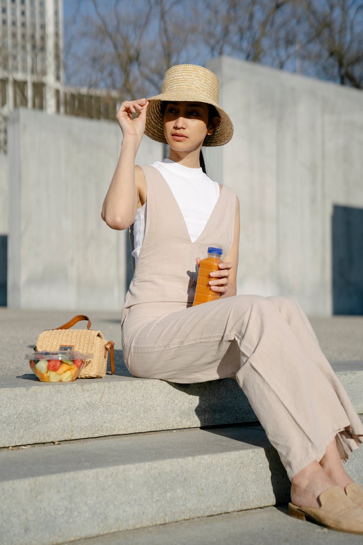 Stylish Asian Woman In Straw Hat On Urban Stairs