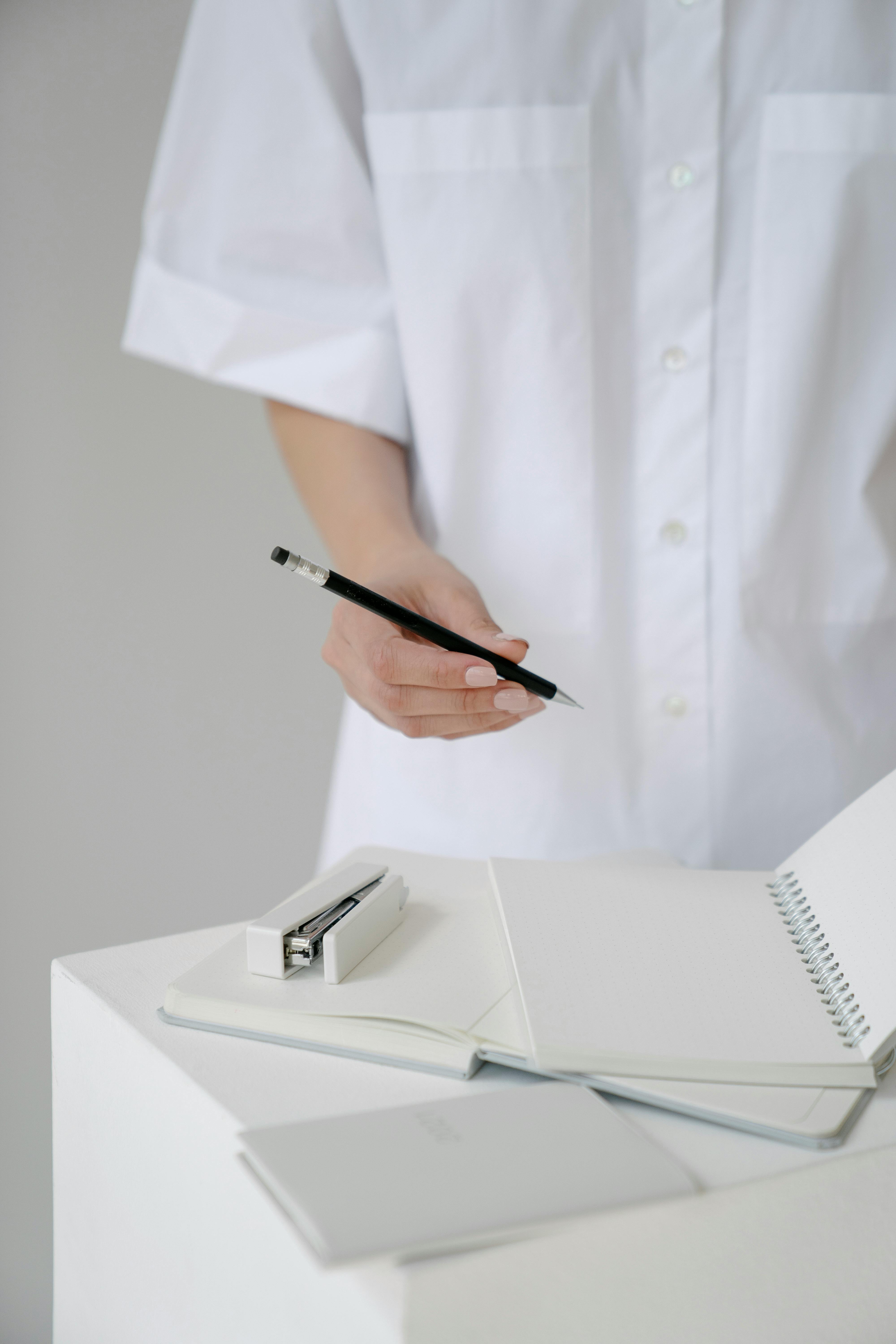 crop doctor with pencil and blank notepads in clinic