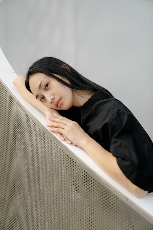 Free Relaxed Asian woman leaning on metal fence Stock Photo