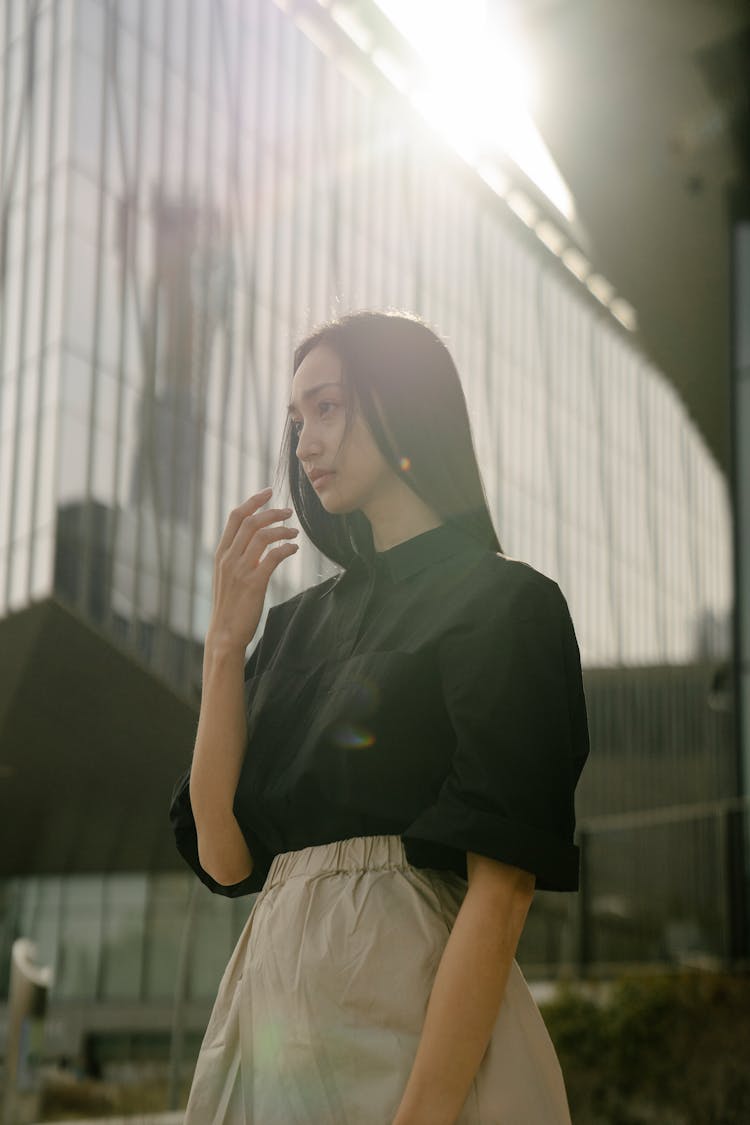 Serious Asian Woman Standing Near Modern Multistory Building