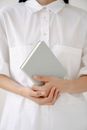 Crop employee in white shirt with diary