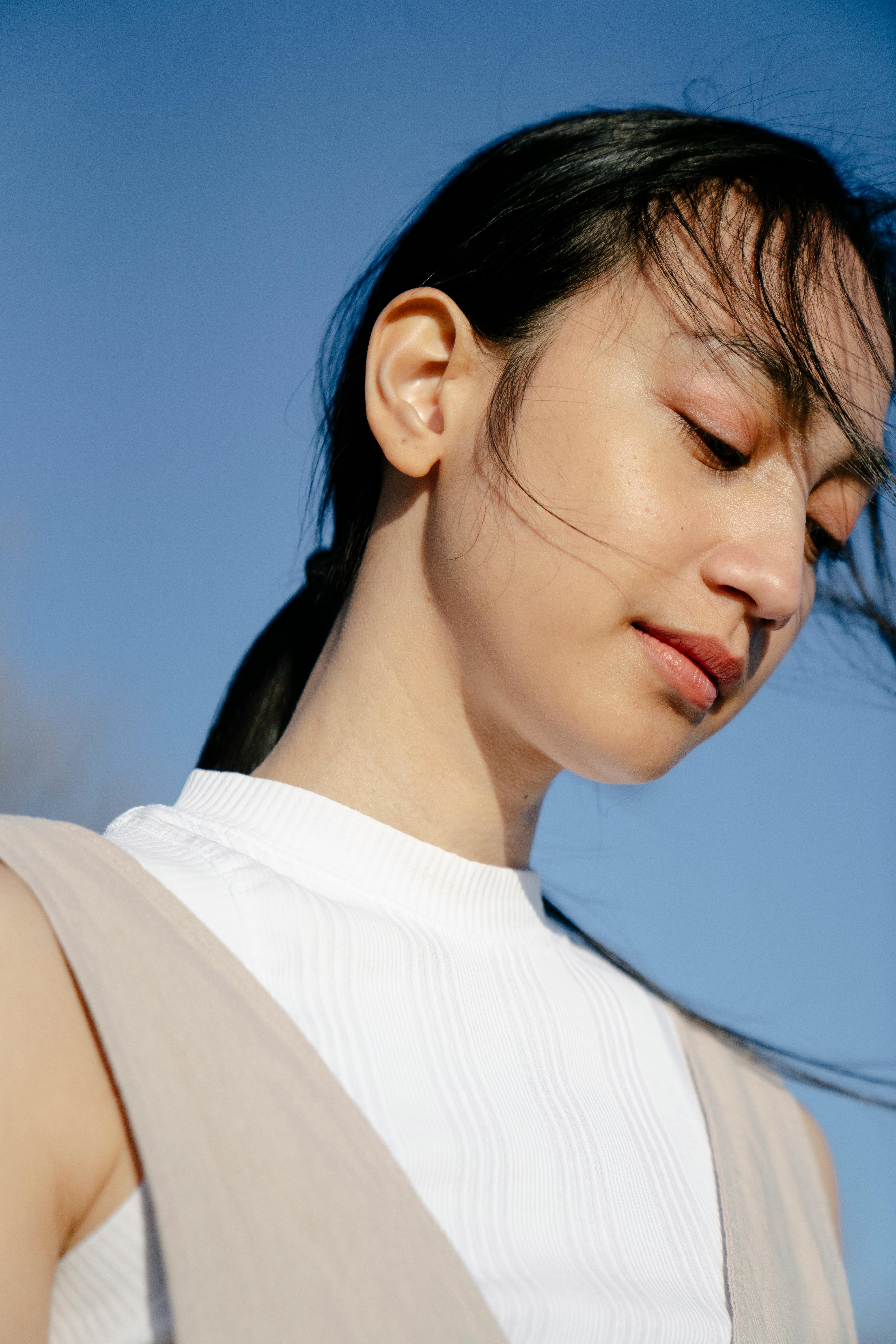 charming asian woman under blue sky in sunshine