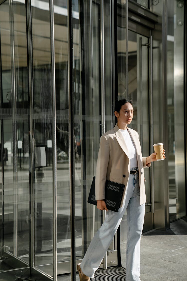 Stylish Ethnic Entrepreneur With Laptop And Takeaway Coffee In Town