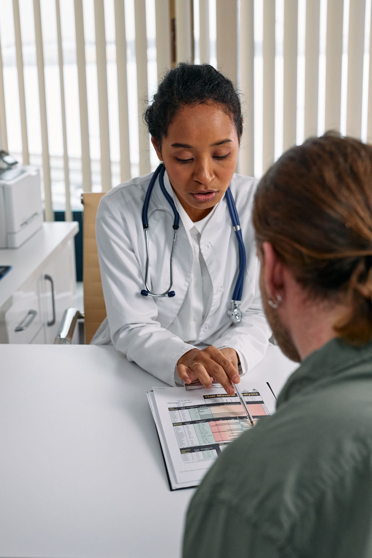Board-certified plastic surgeon consulting patient