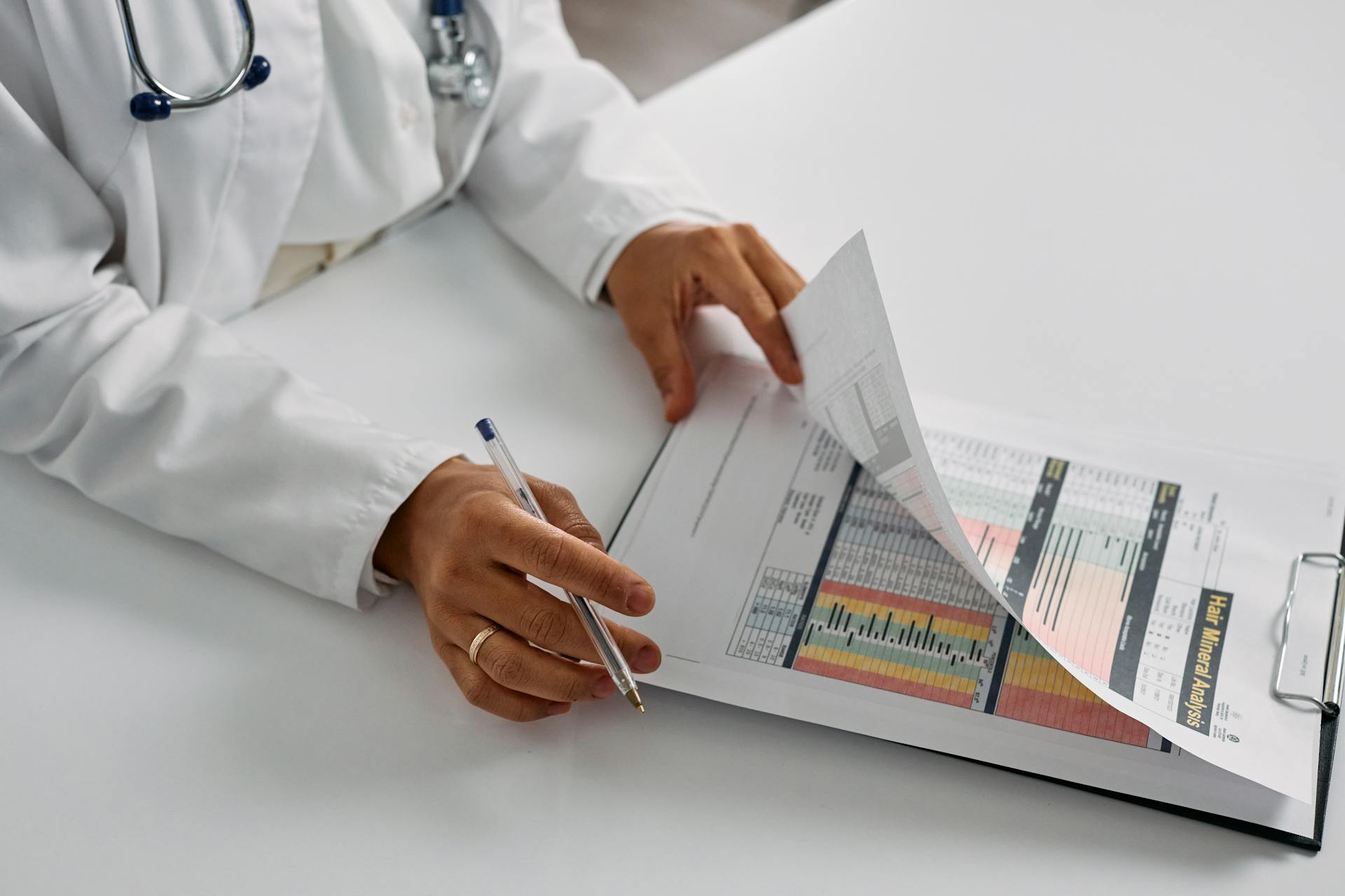 A medical professional checking patient reports with a clipboard in an office setting.