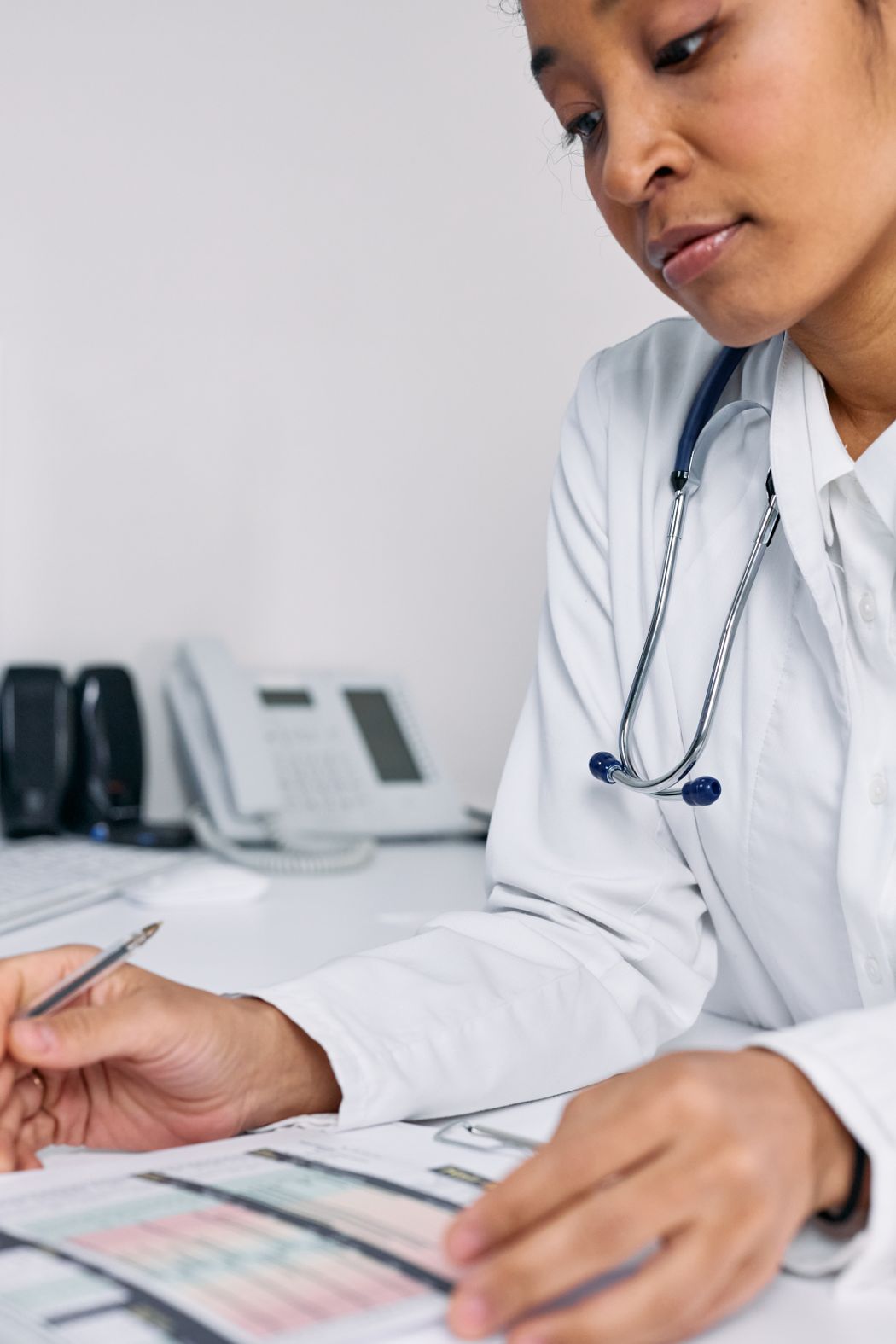 Physician reviewing clinical paperwork and a medical record