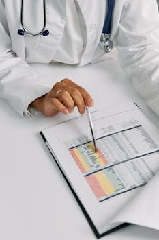 Doctor analyzing patient charts with a pen, focusing on data points for medical insights.