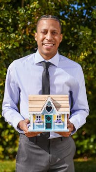 Professional realtor holding a small house model, symbolizing real estate and new home purchases.