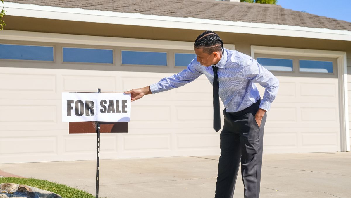 Real estate agent setting up a for-sale sign