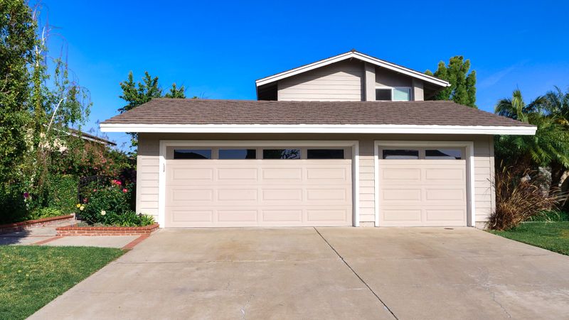 Front exterior of a California-style family home with garage and lawn — the type of property affected by rising homeowners insurance rates