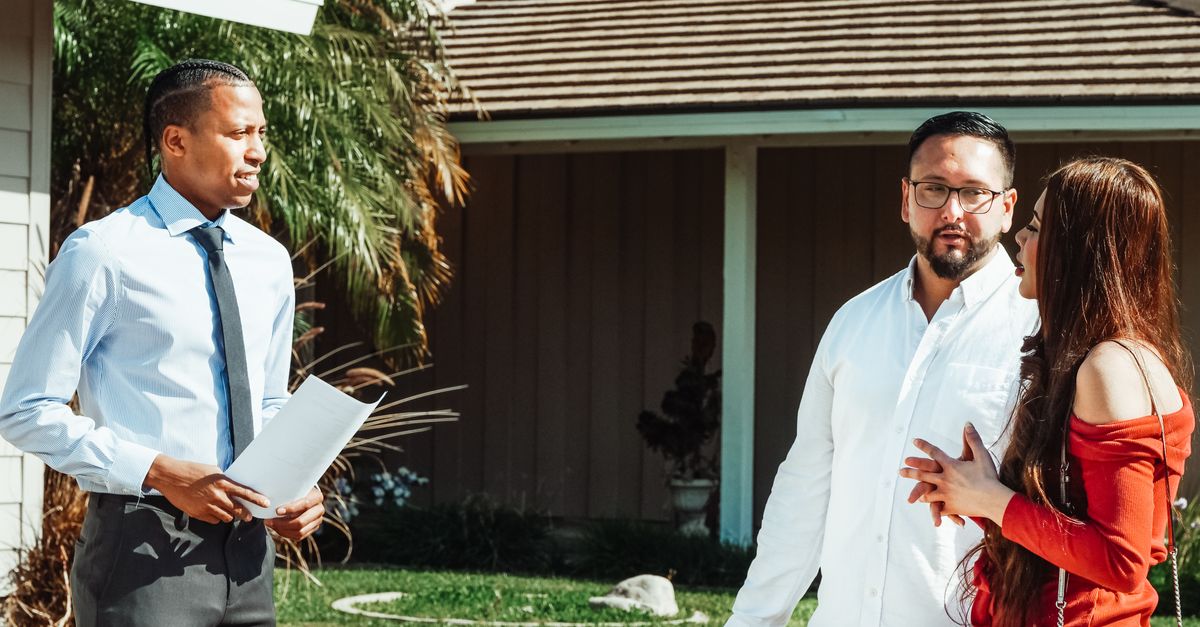 A real estate agent showing a house to a couple, discussing options. — specialist vs generalist cash home buyer