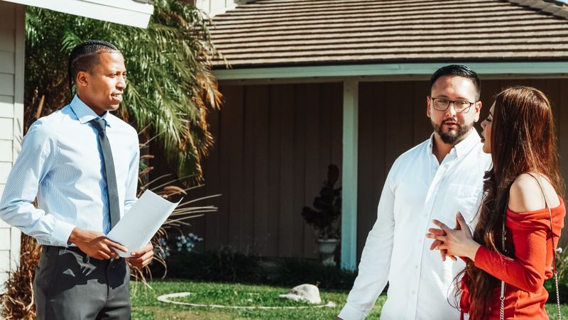 Homeowner couple reviewing gutter inspection report with ClearFlow technician