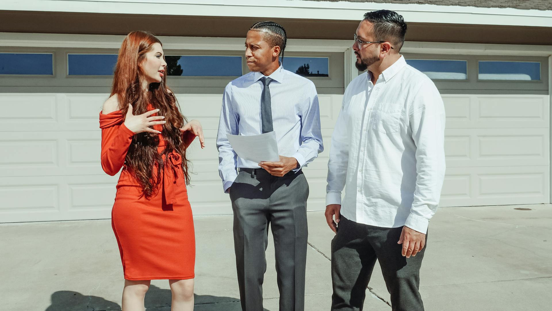 A young couple talking to a real estate agent outside a modern home.