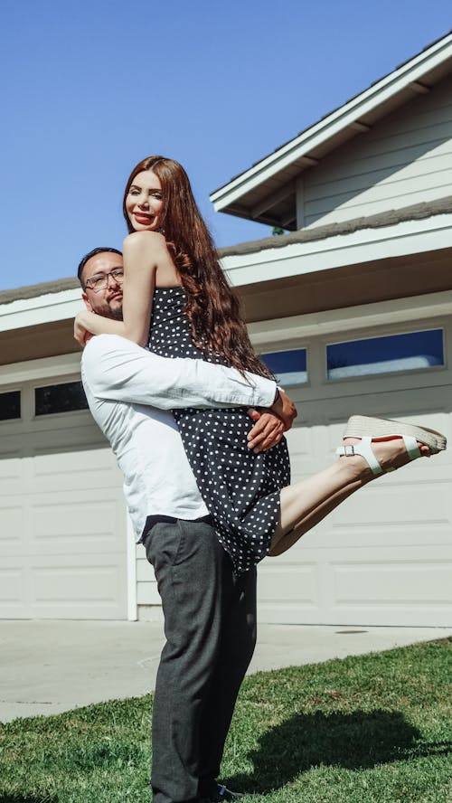 Free Man Carrying a Woman In Front of their House Stock Photo