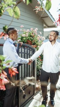 A friendly handshake between two men, symbolizing a successful real estate deal.