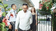 Young couple with realtor exploring potential new home during a sunny day.