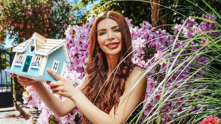 Woman Holding A Miniature House