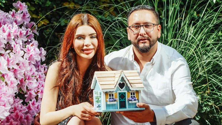 Couple Holding Miniature House