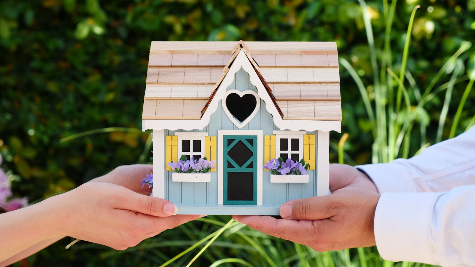 illustration d'acquisition d'une maison, avec une miniature de maison à la main