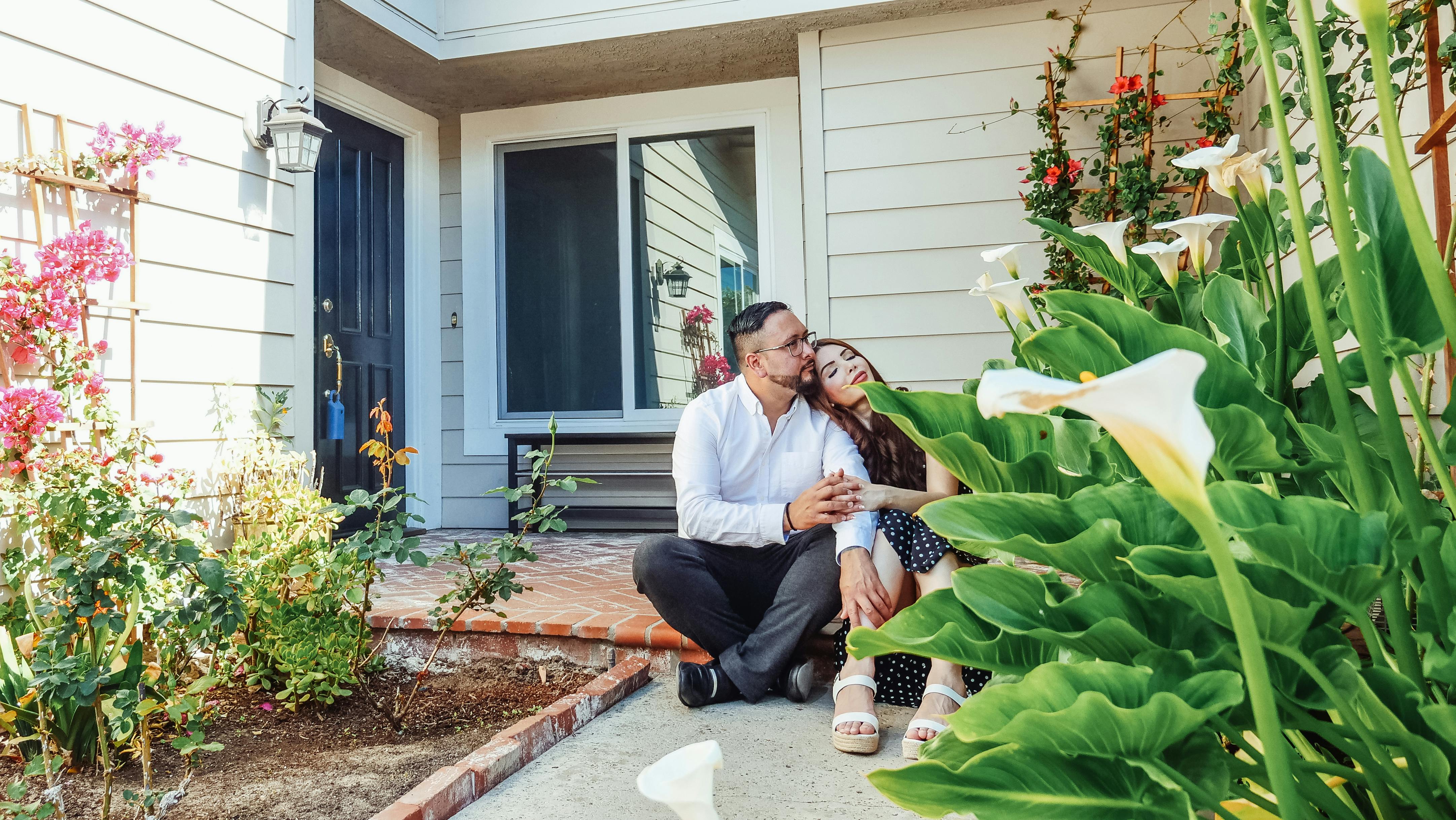 couple sitting in front of their house