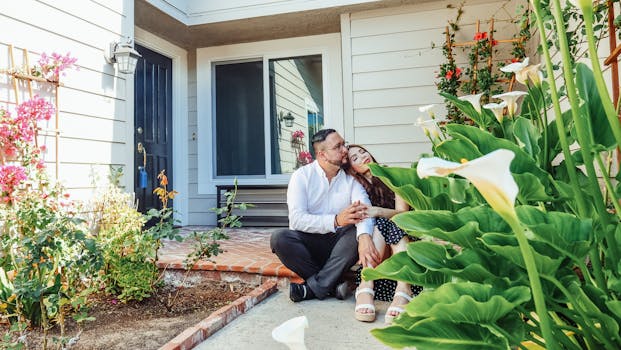 A happy couple sits by their home's entrance surrounded by lush flowers, symbolizing new beginnings.
