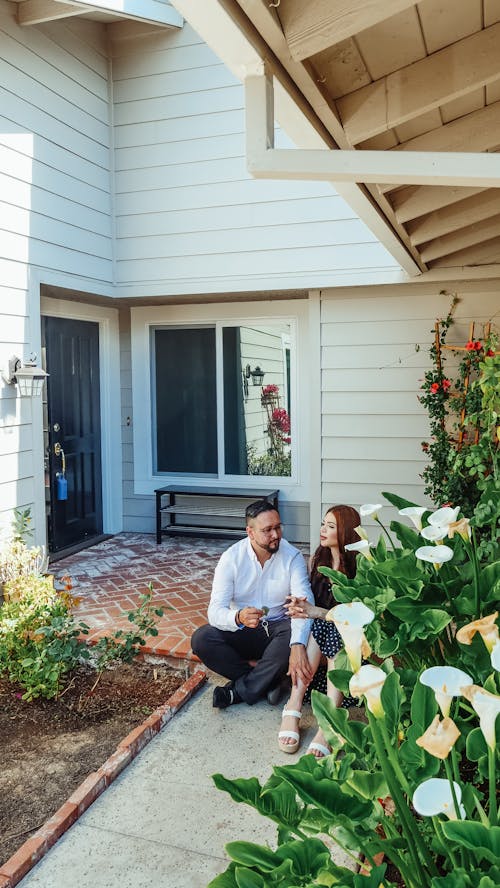 Free Man and Woman Sitting In Front of their House Stock Photo