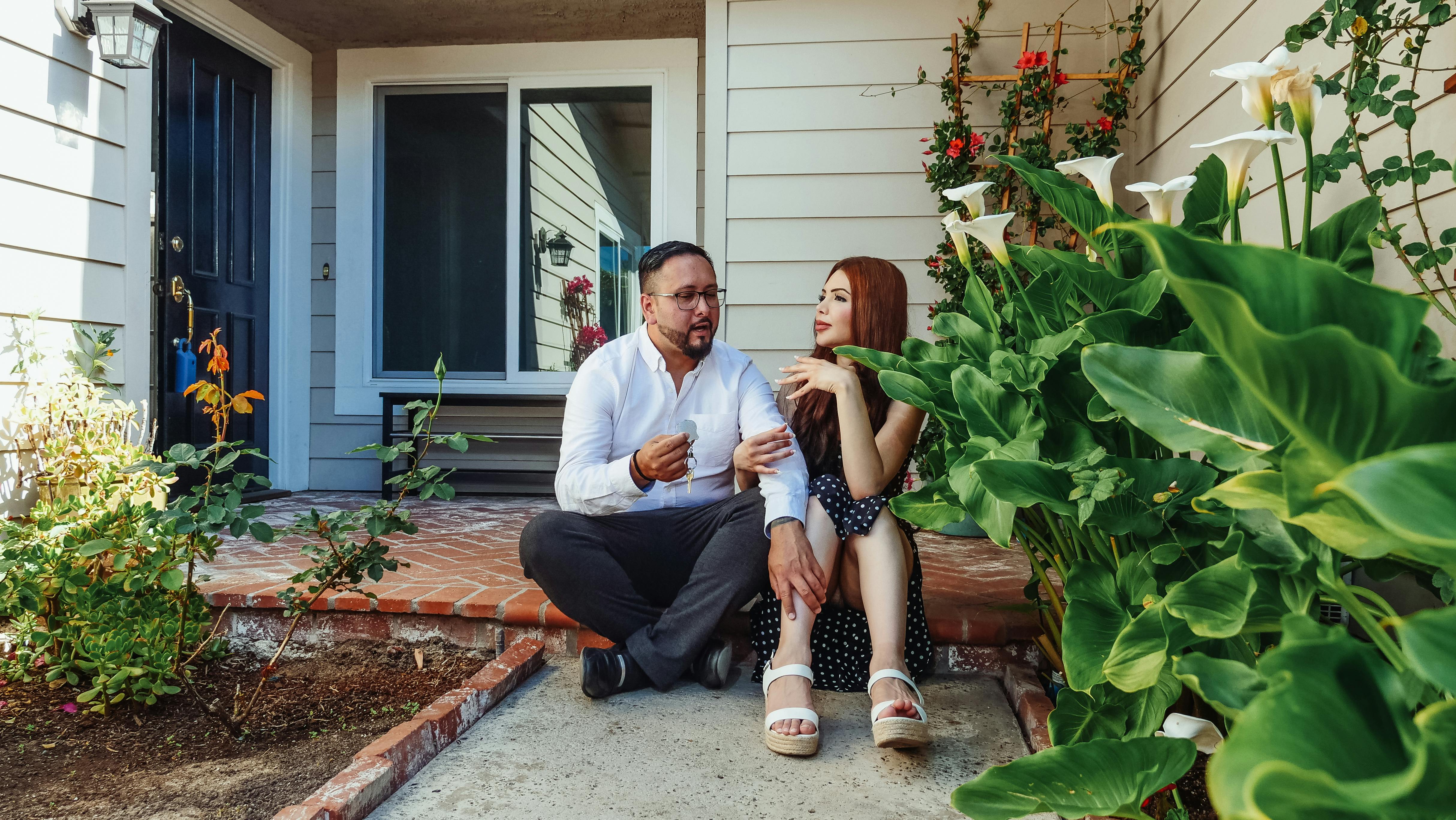 man and woman sitting in front of their house