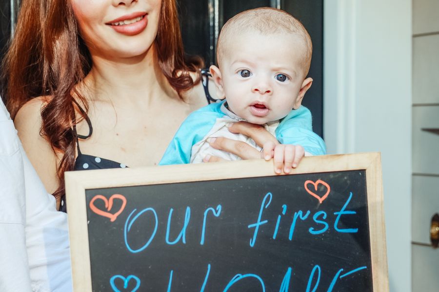 Family holding a sign announcing their first home
