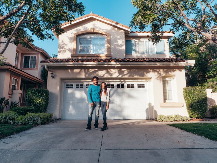 Couple Standing In Front Of Their House