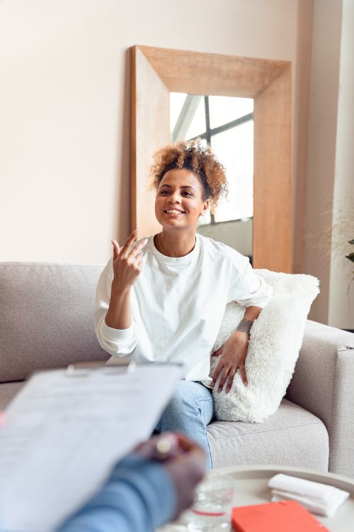 Free Smiling woman in a therapy session on a comfortable sofa. Stock Photo