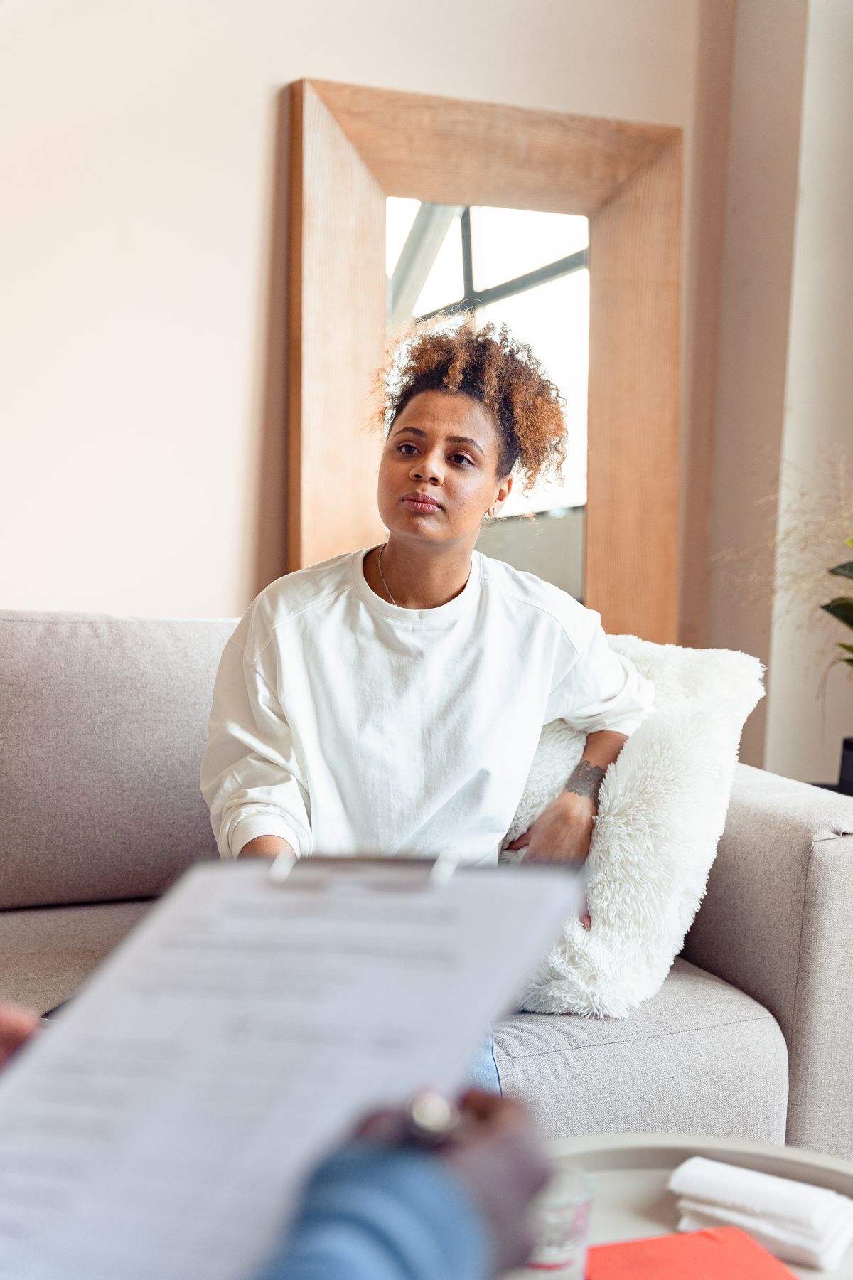 A client sitting calmly on a couch during a supportive conversation