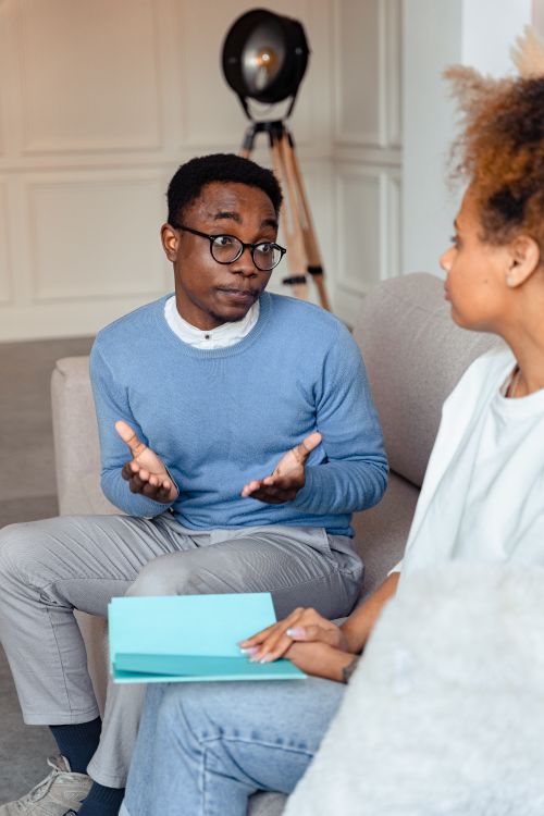 Free A couple having a thoughtful conversation indoors, focusing on mental health. Stock Photo