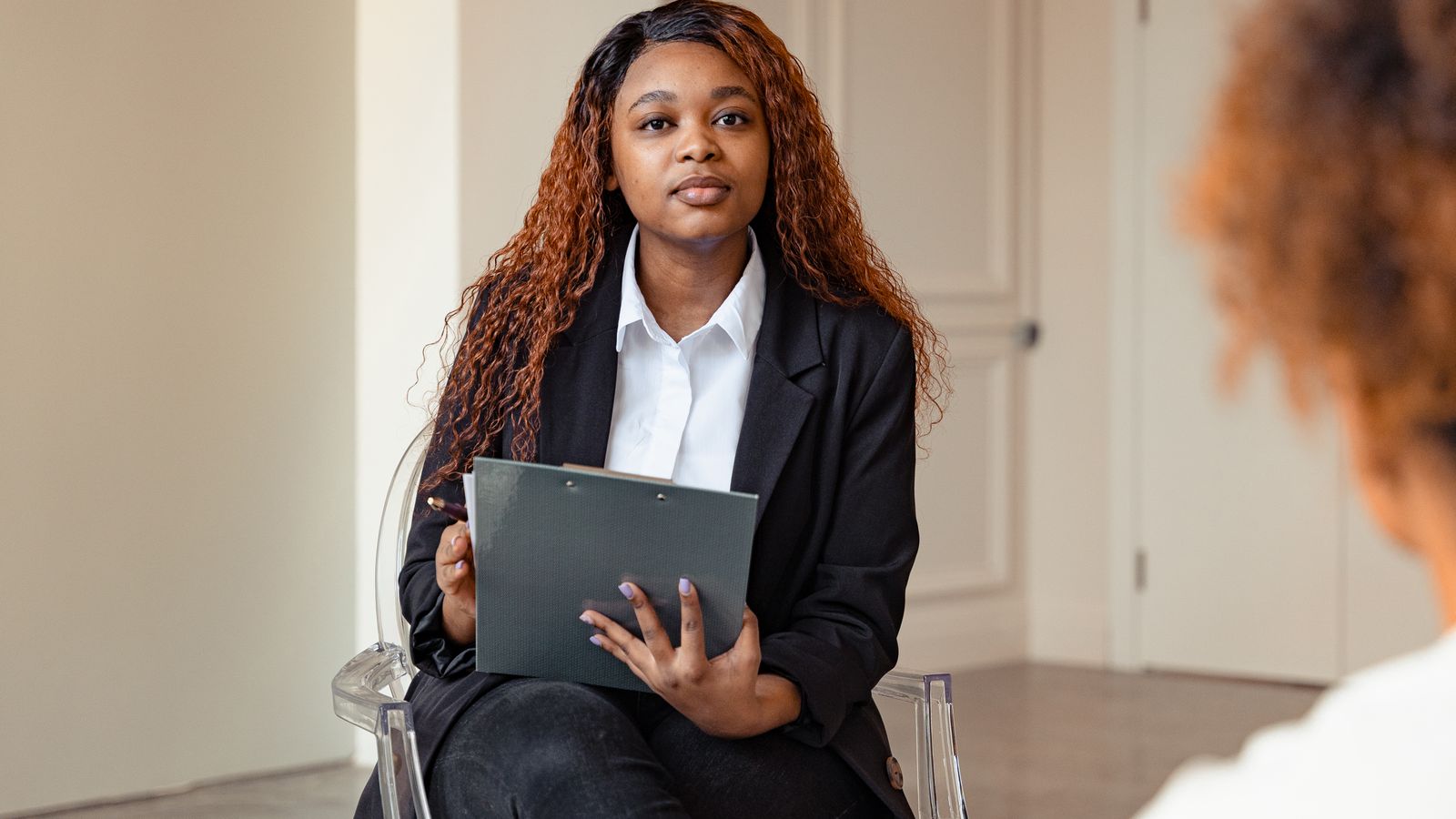 A counselor attentively listens during a therapy session, fostering mental health support.