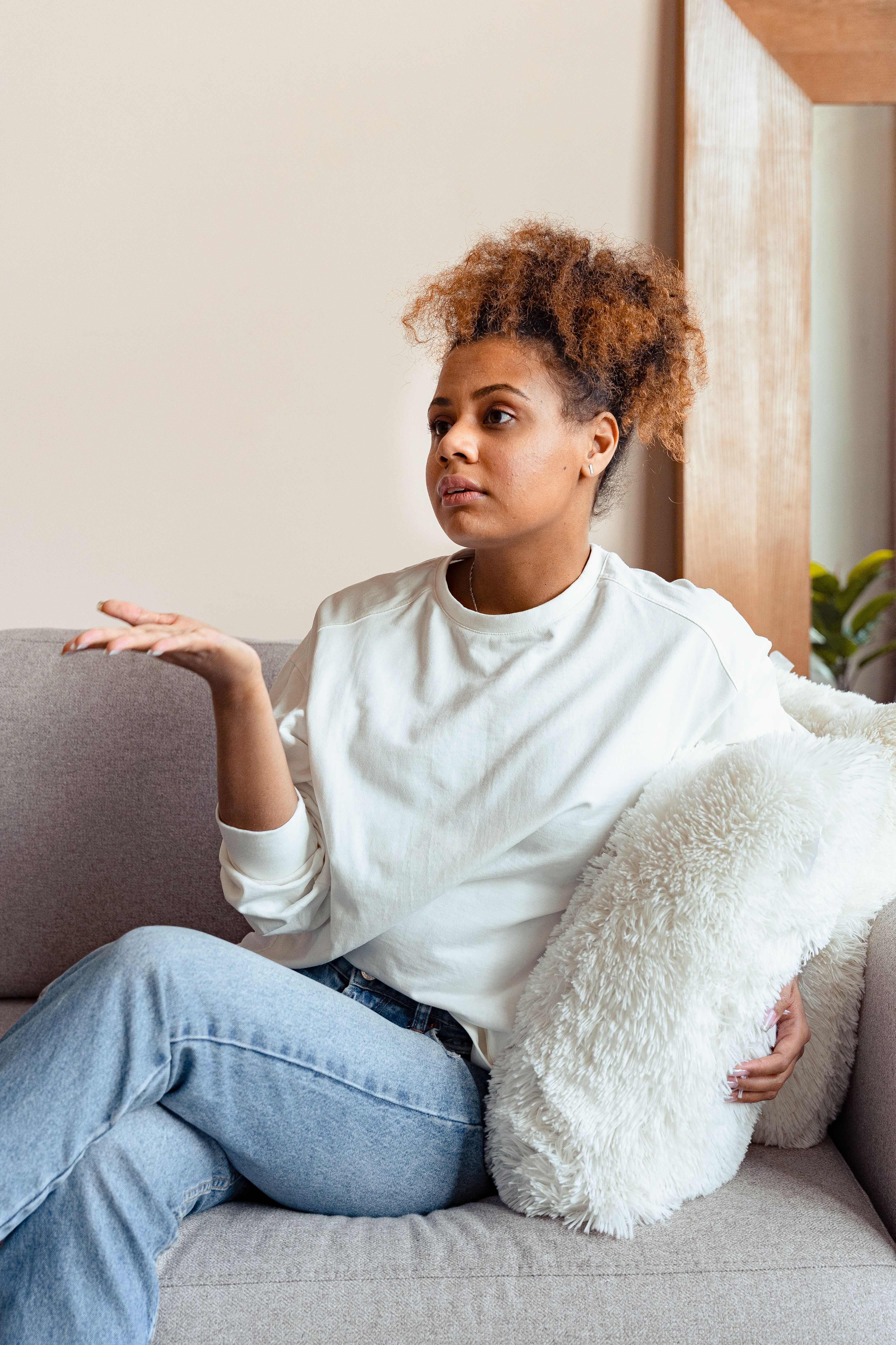 Woman in White Long Sleeves Sitting on a Couch · Free Stock Photo