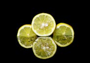 黑色背景上，充满活力的柠檬切片倒影清晰，非常适合表现新鲜和健康的主题