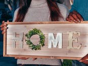 People Holding a Wooden Home Decoration