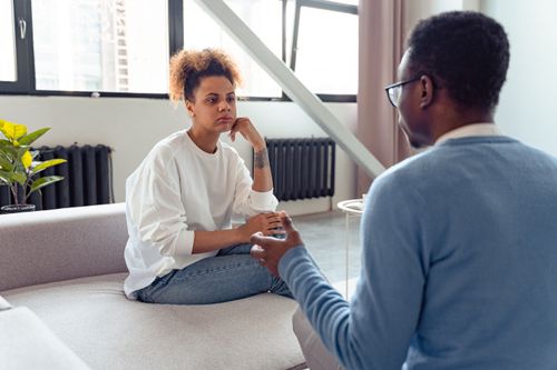 Free Two individuals engaged in a thoughtful therapy session indoors. Stock Photo