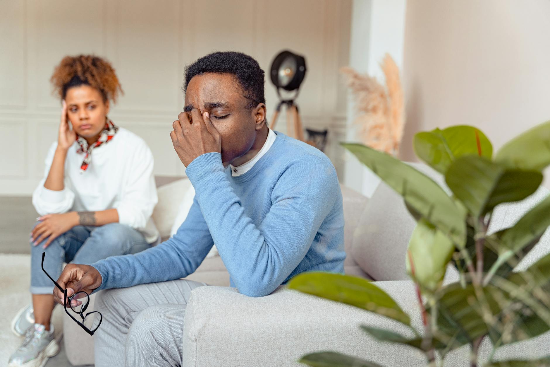 Person Looking Worried Next To A Flat Tire With Another Person Offering Help