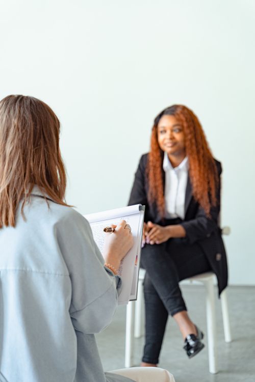 Free A female counselor conducts a therapy session with a client in a modern office setting. Stock Photo