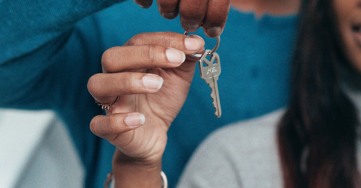 Photo by Kindel Media A couple holding a key, symbolizing a new home ownership or rental.