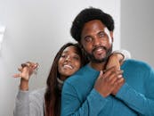 Woman Holding a Key with a Man in Blue Long Sleeve Shirt